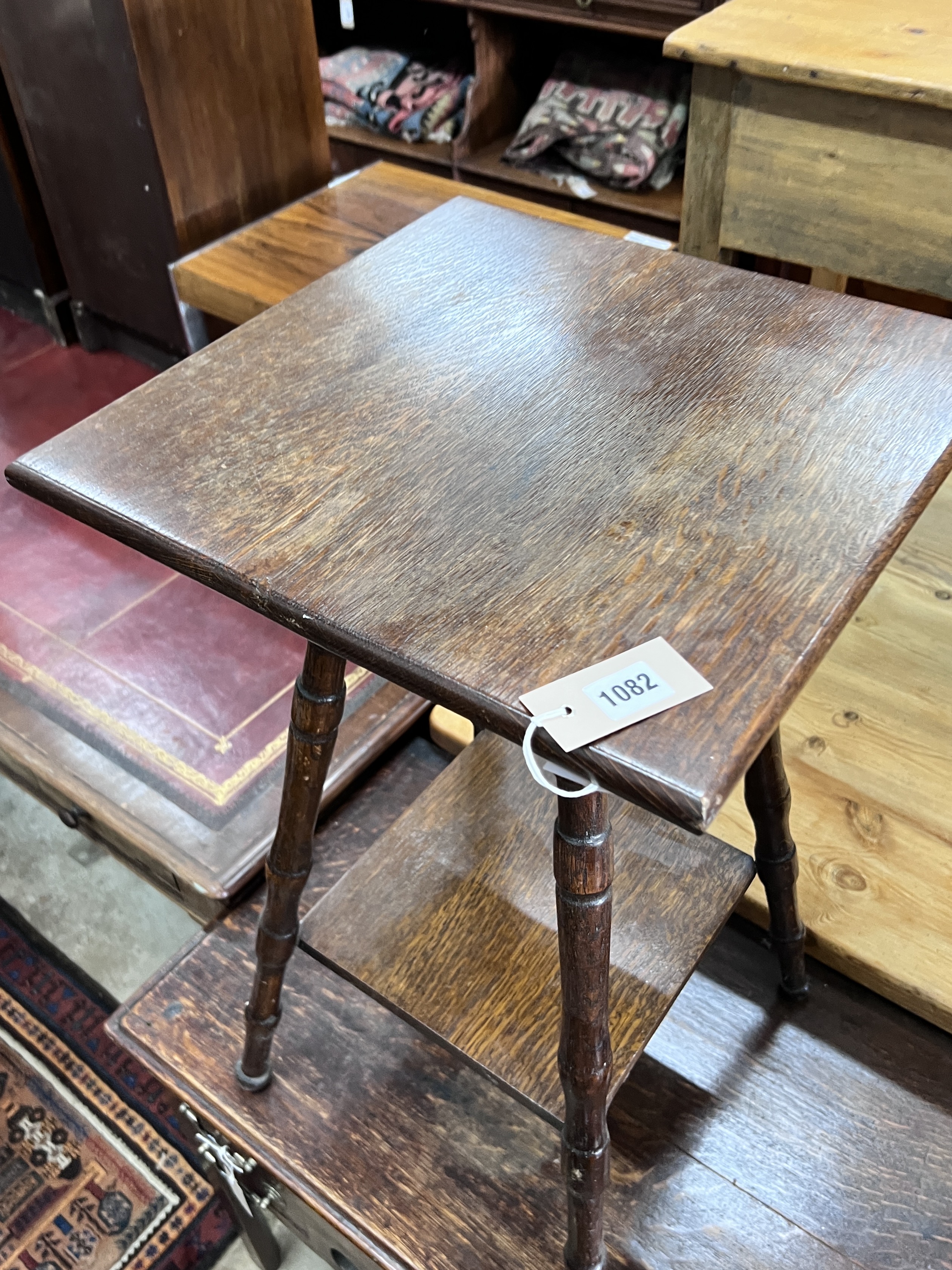 An early 20th century two tier oak occasional table, width 40cm, height 72cm